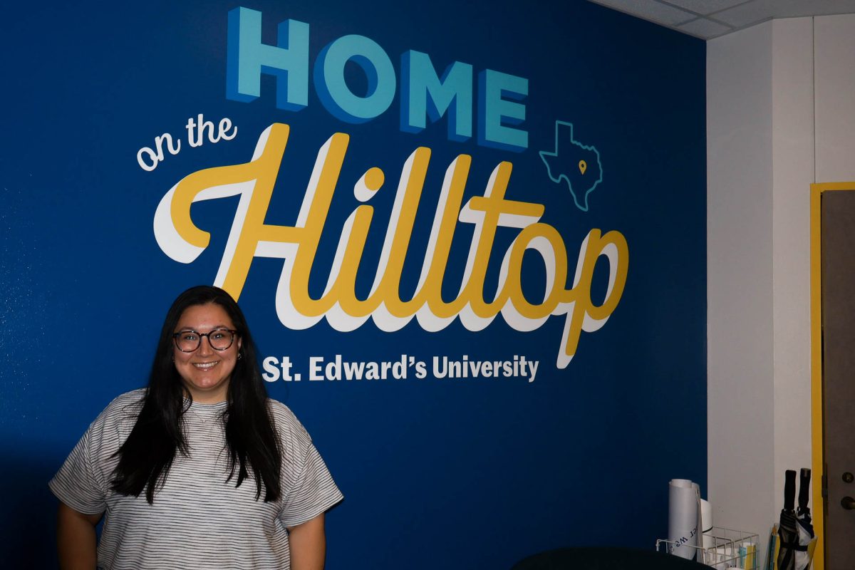 Erica Zamora, director of the Office of Student Belonging and Inclusive Excellence (OSBIE), poses in front of their new welcome sign in the office. Zamora said the decal is meant to “evoke a sense of belonging” for any student – their home is on the hilltop. 