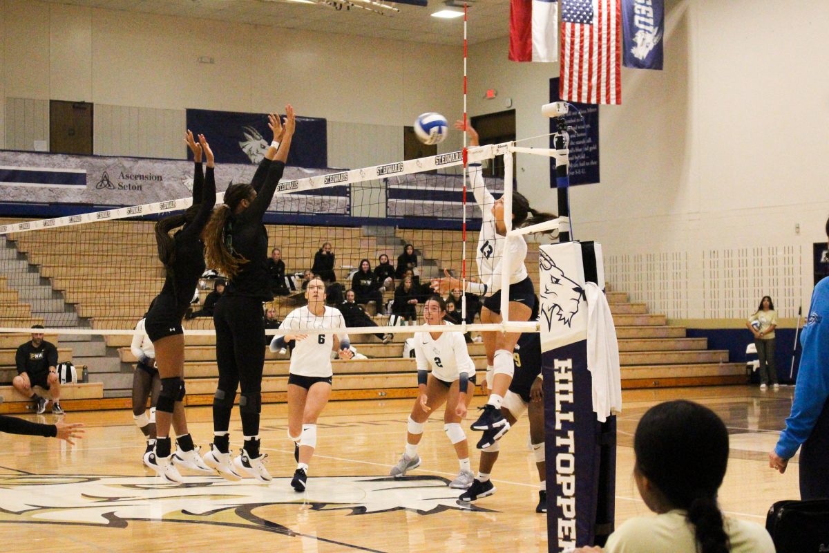 Sophomore outside hitter Kelli Fording jumps with her hands above the net, going for a kill. In volleyball, a kill is a ball from the attacking team that results immediately in a point. Fording was the scoring leaders for the Hilltoppers, scoring 13 total.