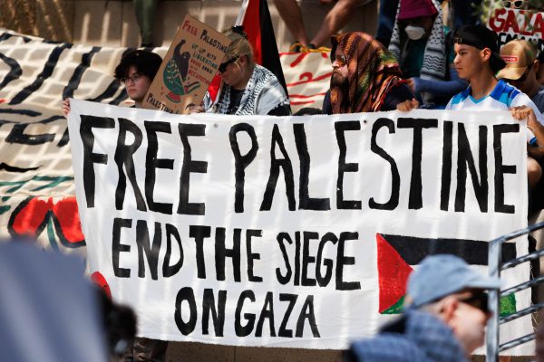 Community members hold a banner reading “Free Palestine, end the siege on Gaza” on the steps of Austin City Hall while listening to fellow community members give speeches and sing songs to celebrate the resilience of Palestine, while simultaneously protesting the ongoing  attacks occurring in Gaza.