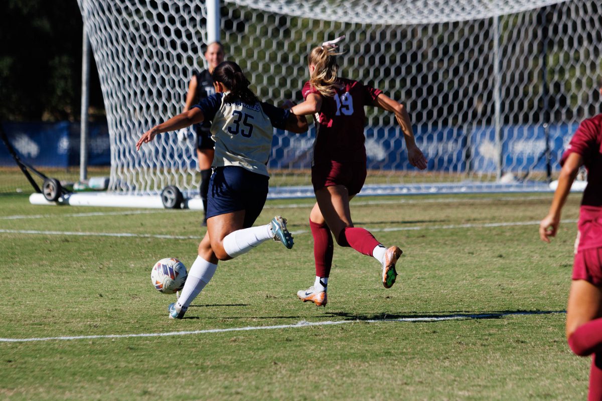 Annie Rocha shoots for a goal while a Texas A&M player tries to block her shot. Rocha was the player of the match, scoring both goals in the first half, just 10 minutes apart from each other.