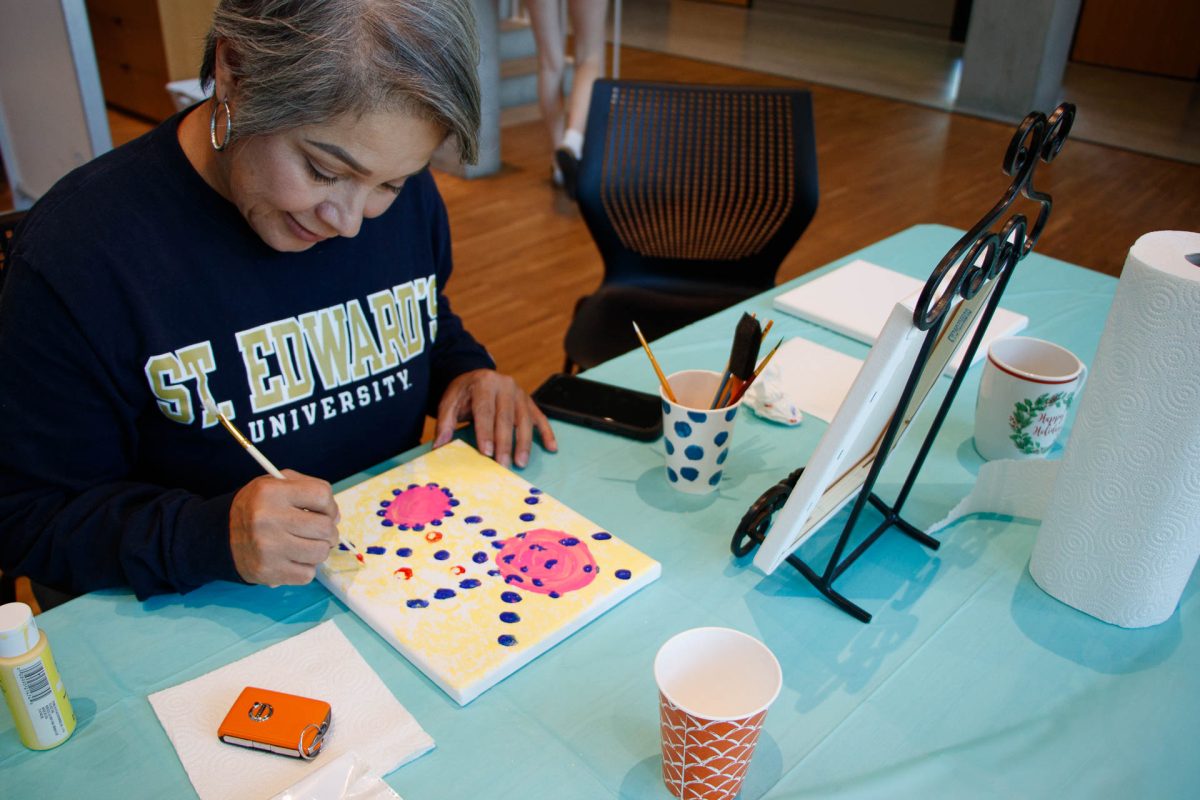 Latinx on the Hilltop provided an art corner at the event to use in between and during speakers. Melissa Esqueda, Ph.D., creates expressive artwork using the paint and canvases that were included.