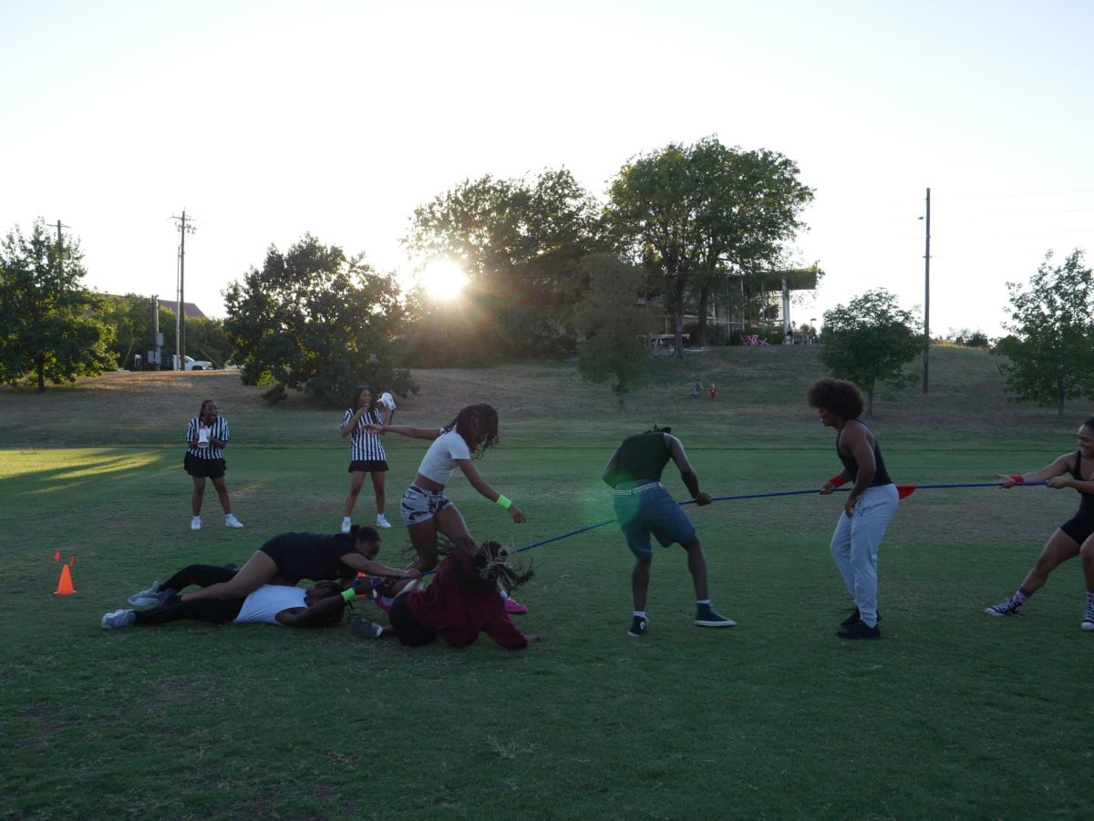 Students playing tug-o-war on Teresa Hall Soccer Field. 