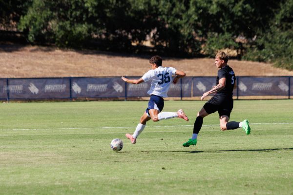 Freshman forward Christian Mezas runs up the field towards the box in an attacking effort against an Oklahoma Christian defender. Mezas was one of the players responsible for assisting Arthur Souza, who scored the goal for the Hilltoppers at the 82nd minute.