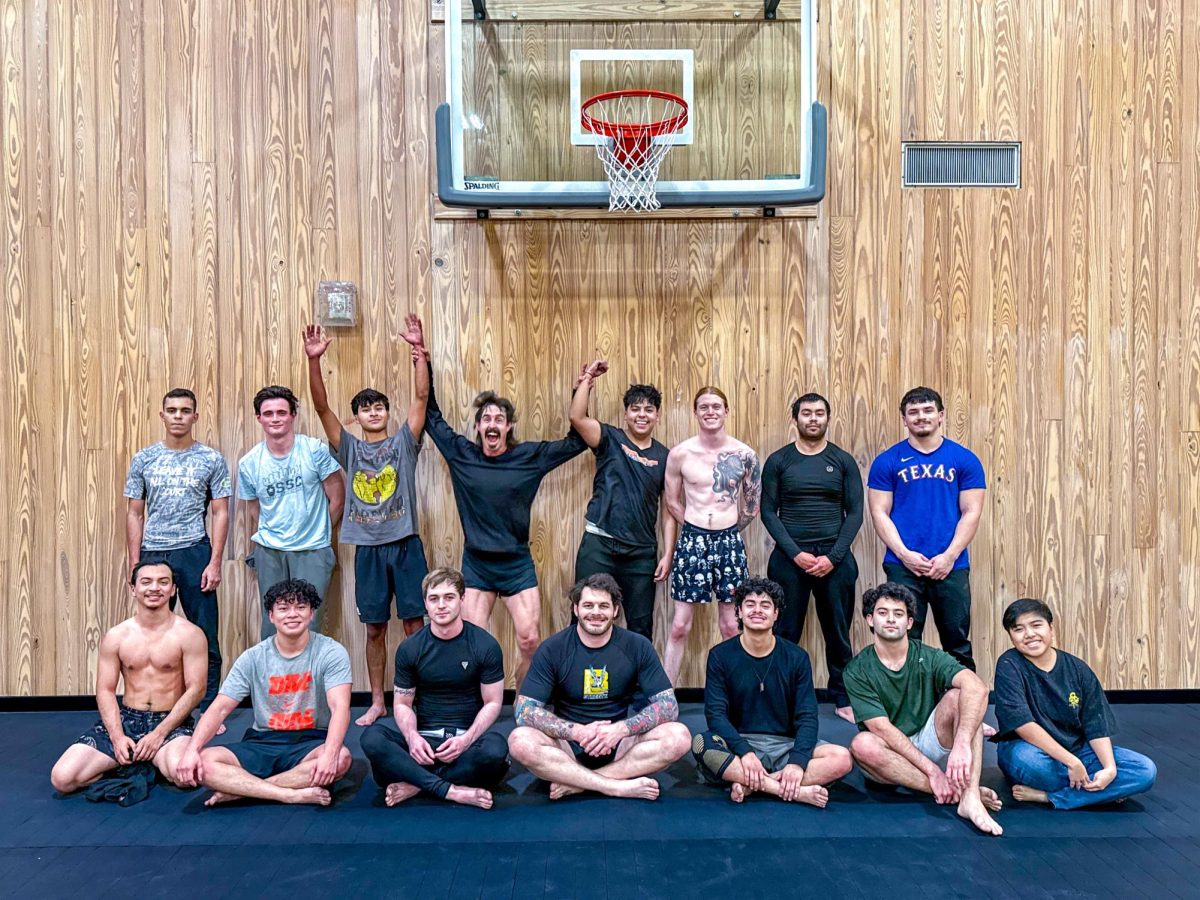 Members of the Brazilian Jiu Jitsu club pose after practice at the UFCU Alumni Gym. Aaron Hines (bottom, center) is the founder of the club and a brown belt for B-Team Jiu Jitsu. The club is open for all and offers classes at the beginners level every Tuesday and Thursday from 5:30 to 7:30 p.m.